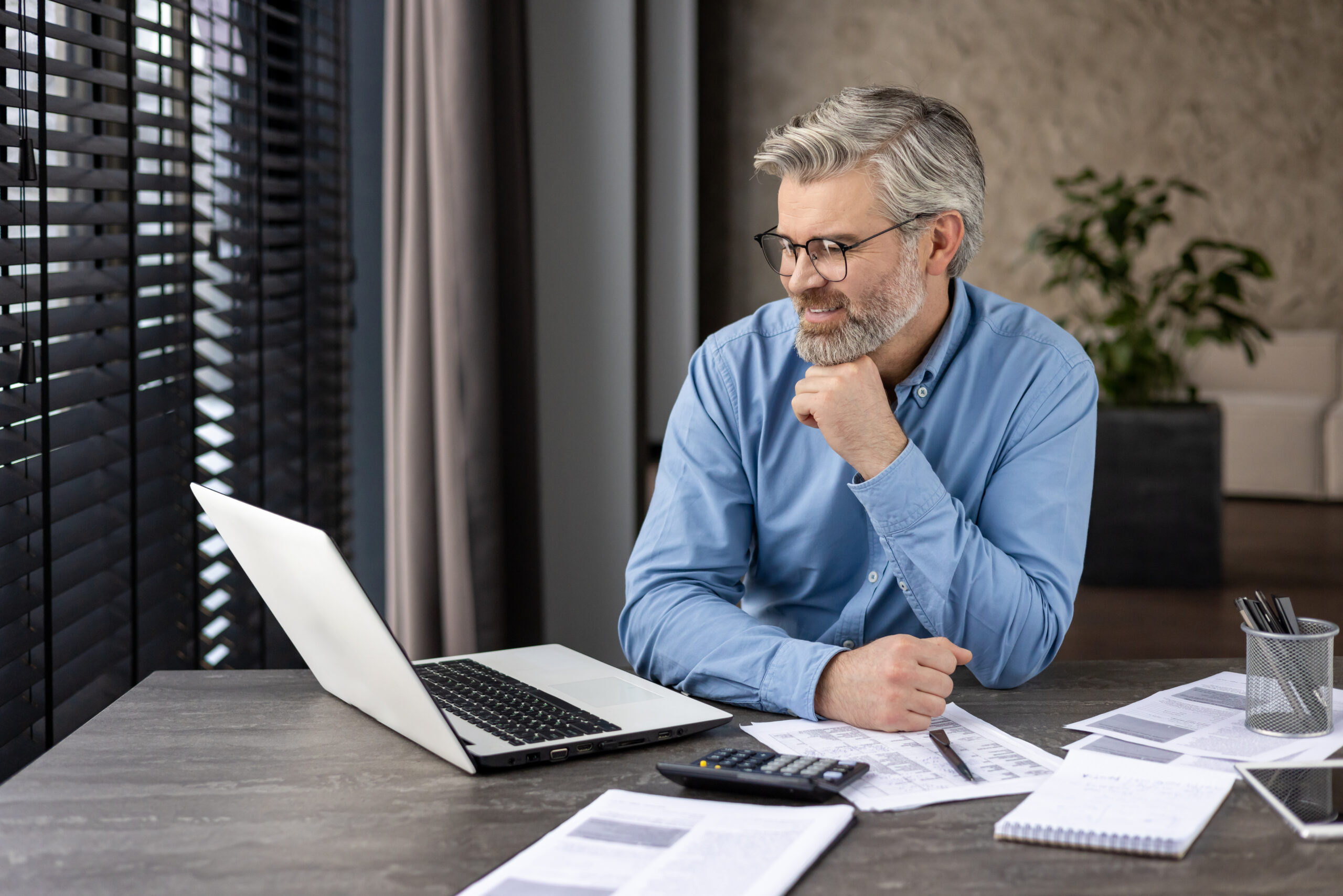 Homme devant son ordinateur avec des papiers sur son bureau - comprendre les acteurs clés de la facturation électronique