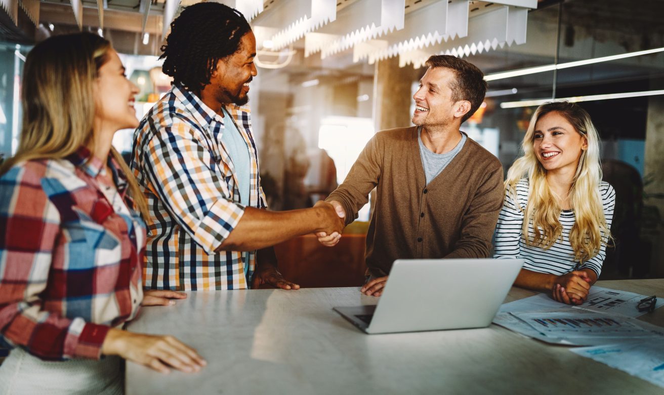 4 personnes dans un cabinet d'expertise comptable, dont 2 qui se serrent la main