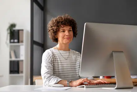 Photo d'une femme qui travaille sur un ordinateur. Intelligence artificielle, assistant IA Lucia dans MEG