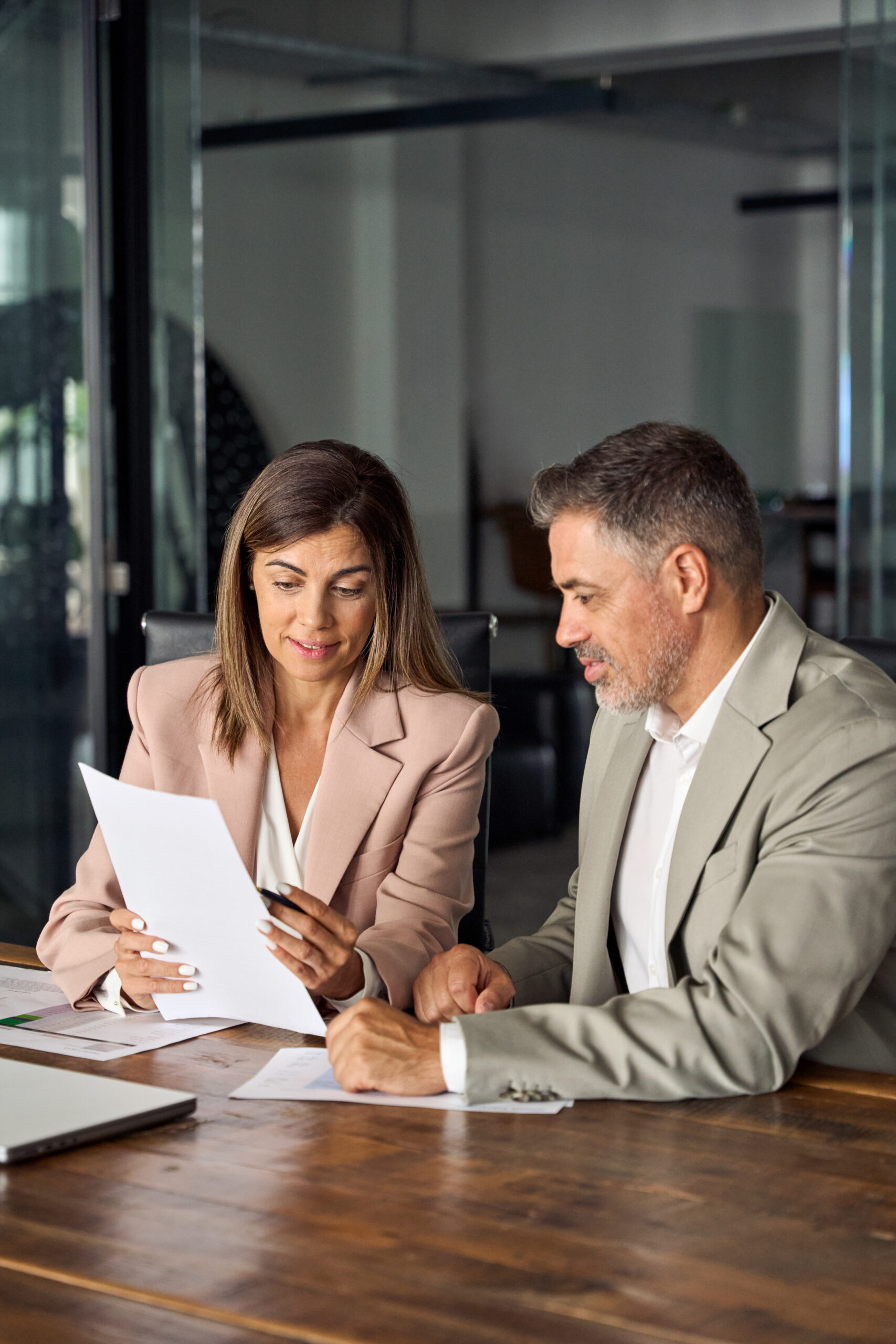 Une expert-comptable en réunion avec un client lui montre un document avec son offre de services