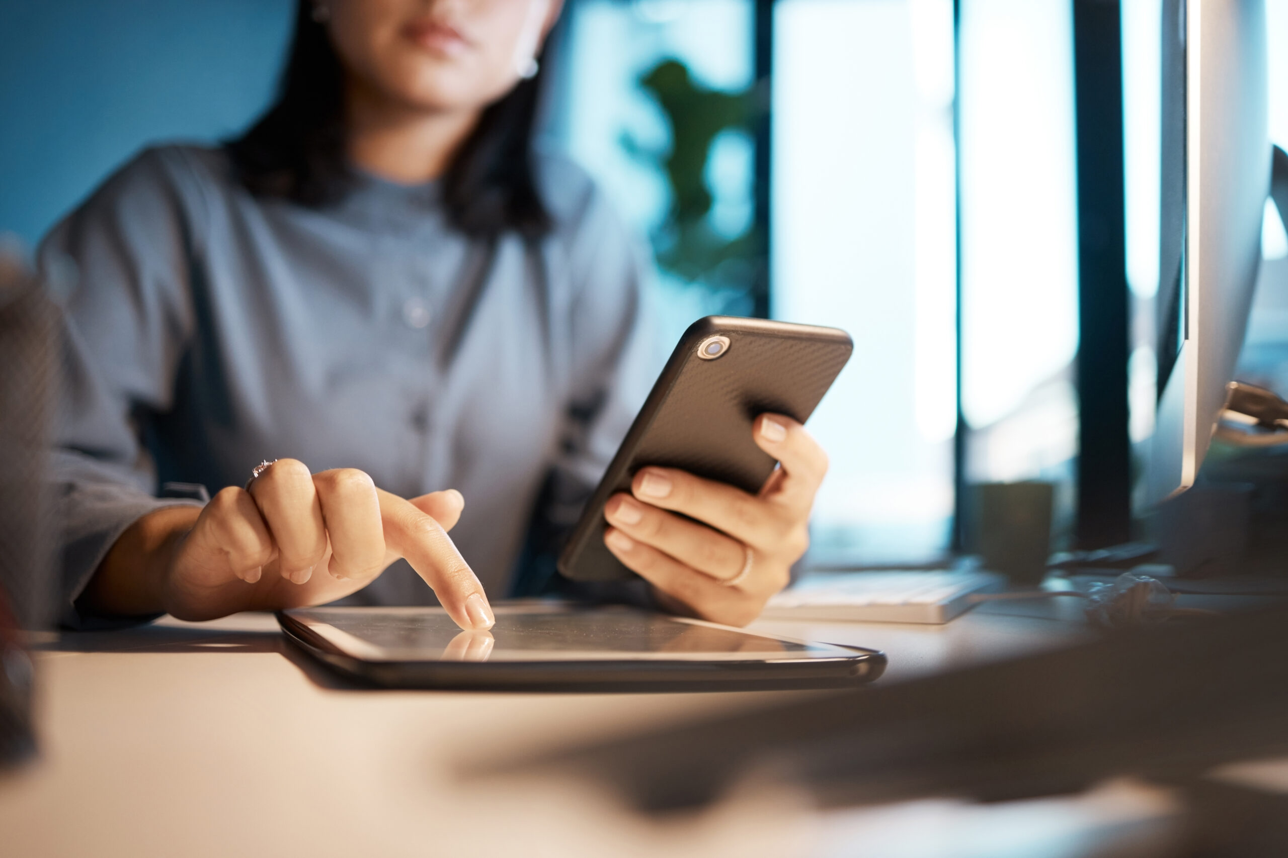 mains de femme et smartphone, tablette et planification dans un bureau sombre, une start-up ou une entreprise.