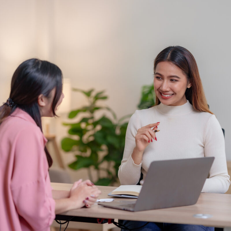 2 femmes discutent dans un environnement de travail, l'une montre son ordinateur à l'autre