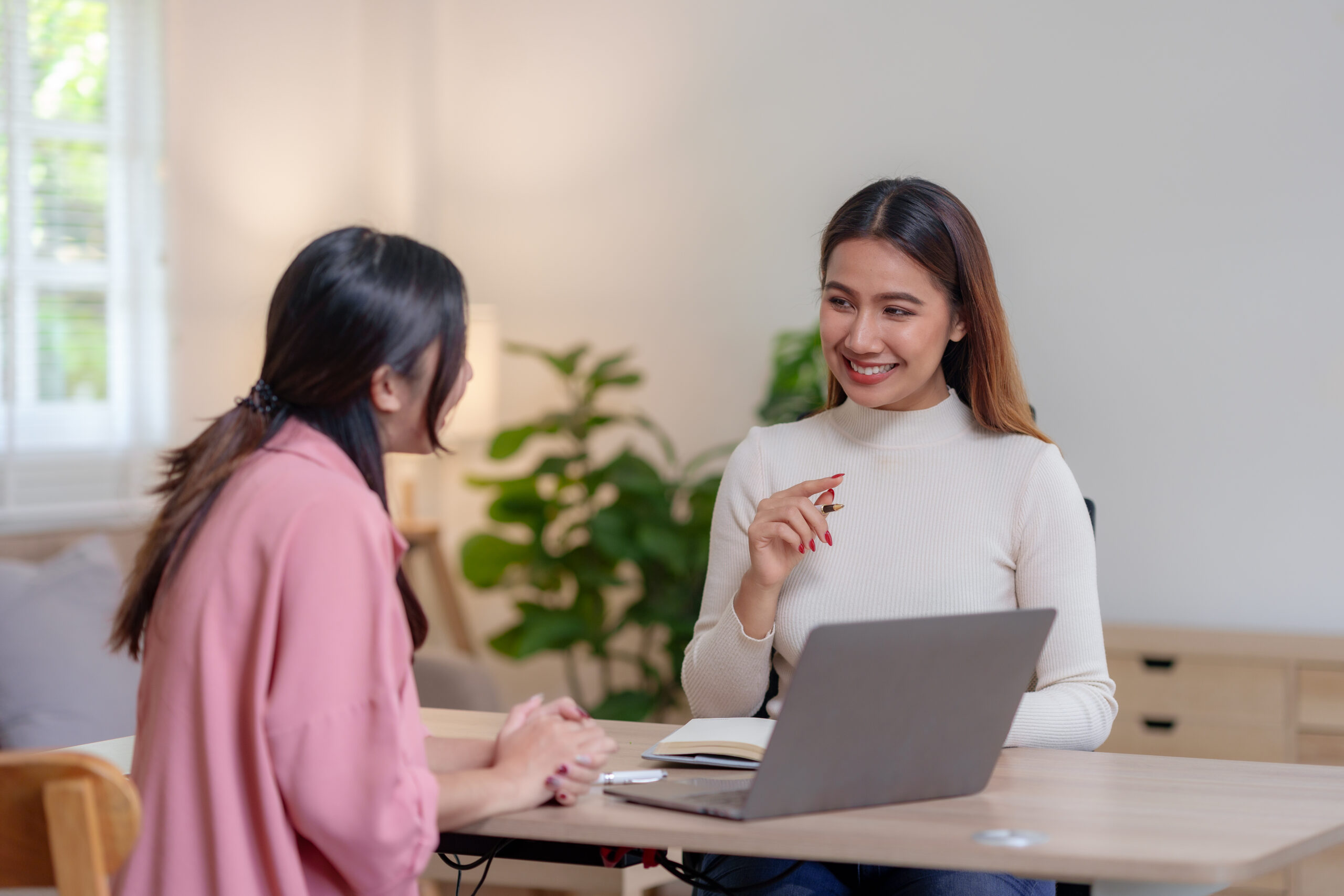 2 femmes discutent dans un environnement de travail, l'une montre son ordinateur à l'autre